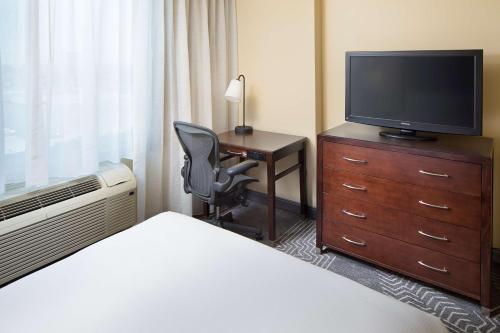 a hotel room with a bed and a desk with a television at DoubleTree by Hilton Los Angeles/Commerce in Commerce