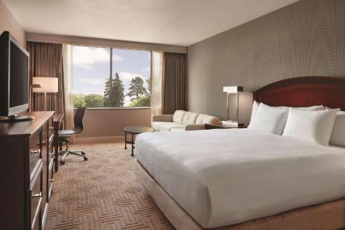 a hotel room with a large bed and a television at Hilton East Brunswick in East Brunswick