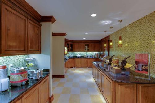 a large kitchen with wooden cabinets and counter tops at Hampton Inn and Suites Fredericksburg South in Fredericksburg