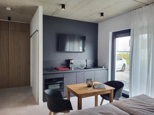 Zimmer mit einem Tisch und einer Küche mit einem TV in der Unterkunft Ferienwohnung Schlossterrassen 4b in Pouch