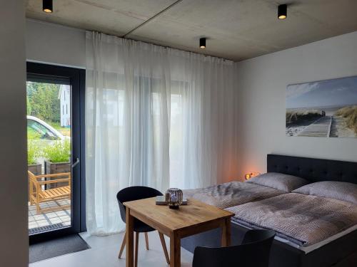 a bedroom with a bed and a table with chairs at Ferienwohnung Schlossterrassen 4b in Pouch