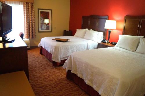 a hotel room with two beds and a flat screen tv at Hampton Inn Altoona in Altoona