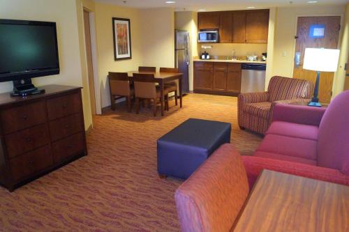a living room with a television and a dining room at Hampton Inn Altoona in Altoona