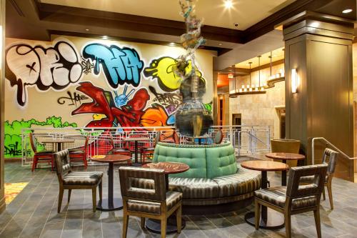 ein Restaurant mit Tischen und Stühlen und eine Wand mit Graffiti in der Unterkunft Hampton Inn and Suites Austin University Capitol in Austin