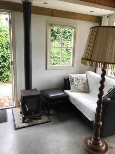 a living room with a bed and a stove at Mamas Cabin in Laag-Soeren