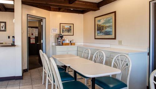 a restaurant with tables and chairs and a counter at Country Squire inn and suites in Coshocton