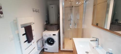 une salle de bain avec une machine à laver et un lave-linge dans l'établissement La Grange, à Auberville