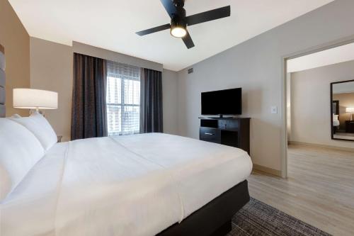 a bedroom with a large white bed and a flat screen tv at Homewood Suites Nashville Vanderbilt in Nashville