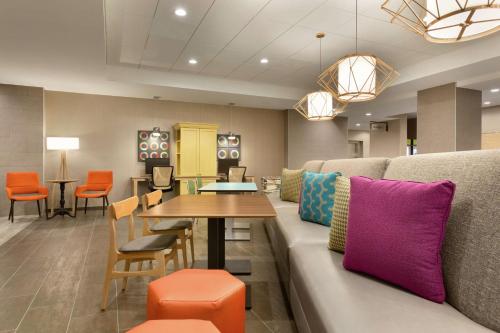 a living room with a couch and a table and chairs at Home2 Suites By Hilton Florence Cincinnati Airport South in Florence