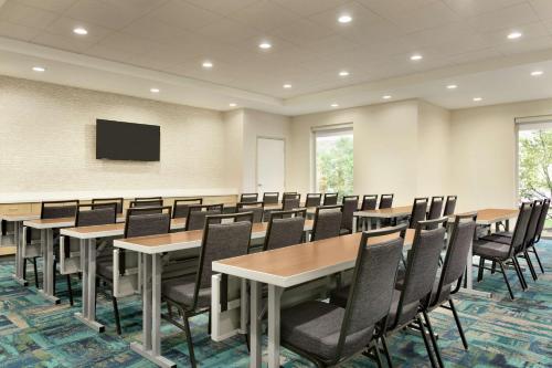 a conference room with tables and chairs and a flat screen tv at Home2 Suites By Hilton Florence Cincinnati Airport South in Florence