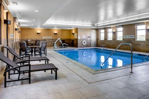 a pool in a hotel room with chairs and a table at Hampton Inn & Suites Dodge City in Dodge City
