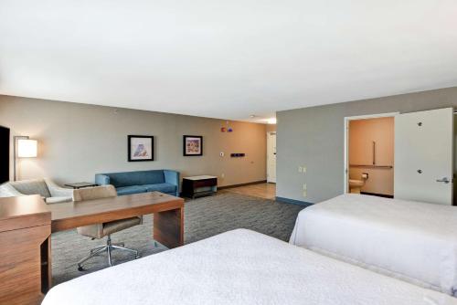 a hotel room with a bed and a desk and a room at Hampton Inn Moab in Moab