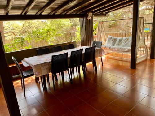 una sala da pranzo con tavolo e sedie su un portico di Villetta Porto Pino 30 mt dalla spiaggia a Porto Pino