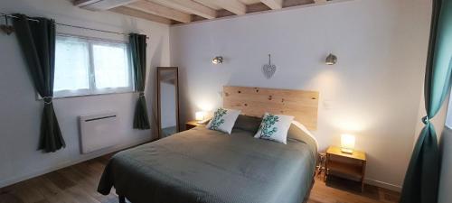 - une chambre avec un lit avec deux oreillers et une fenêtre dans l'établissement La Grange, à Auberville