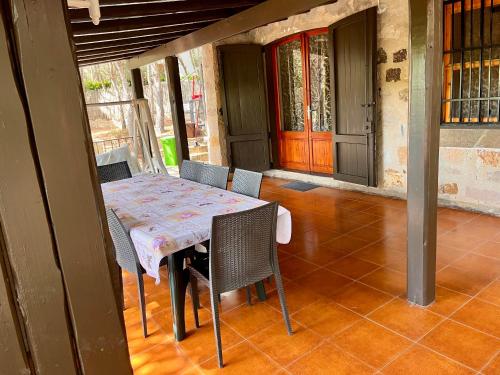 un tavolo e sedie sul portico di una casa di Villetta Porto Pino 30 mt dalla spiaggia a Porto Pino