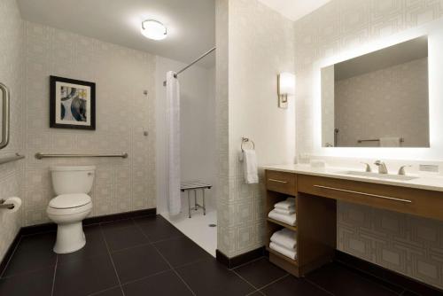 a bathroom with a toilet and a sink and a mirror at Homewood Suites By Hilton Memphis - Southaven in Southaven