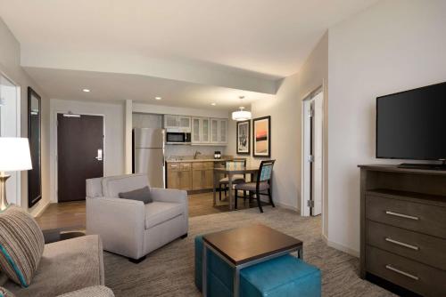 a living room with a couch and a tv and a kitchen at Homewood Suites By Hilton Memphis - Southaven in Southaven