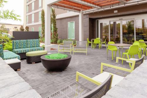 a patio with furniture and tables and chairs at Home2 Suites By Hilton Orlando South Park - Near Epic Universe in Orlando