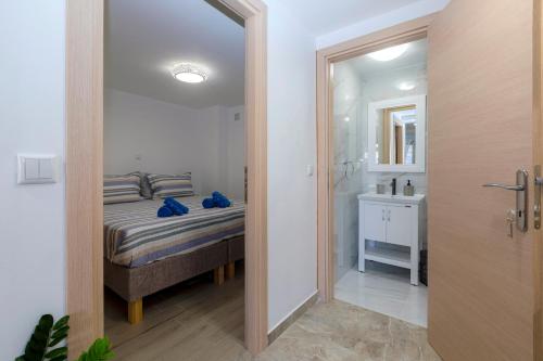 a bedroom with a bed and a bathroom with a mirror at Volto Suites in Corfu Town