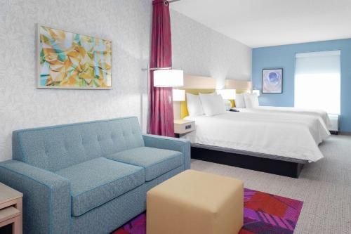 a hotel room with a bed and a couch at Home2 Suites By Hilton Orlando South Park - Near Epic Universe in Orlando