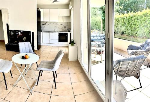 een keuken en een woonkamer met een tafel en stoelen bij A Sainte marguerite in Nice