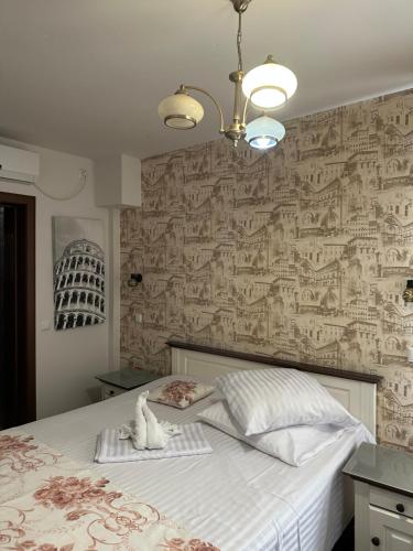 a bedroom with a large bed with a wall covered in wallpaper at Home Simoni in Ploieşti