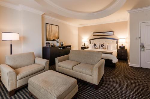 a hotel room with a bed and a couch and a chair at Le St-Martin Hotel Centre-ville – Hotel Particulier in Montréal