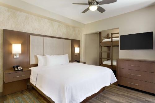 Homewood Suites by Hilton Moab في موآب: غرفة نوم بسرير وتلفزيون بشاشة مسطحة