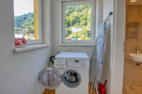 a washing machine in a bathroom with a window at Apartment Leon - by Alpen Apartments in Zell am See