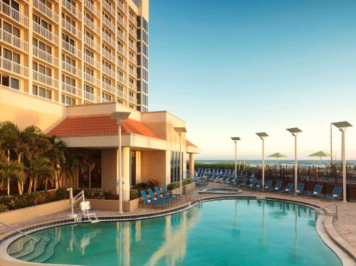 a hotel with a swimming pool in front of a building at Hilton Melbourne Beach Oceanfront in Melbourne