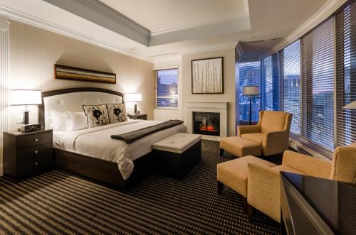 um quarto com uma cama, uma lareira e uma cadeira em Le St-Martin Hotel Centre-ville – Hotel Particulier em Montreal
