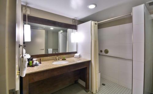a bathroom with a sink and a mirror at Embassy Suites by Hilton Denver Central Park in Denver