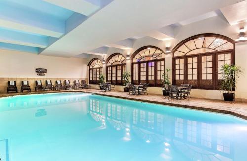 a pool in a hotel with chairs and tables at Embassy Suites by Hilton Nashville Airport in Nashville