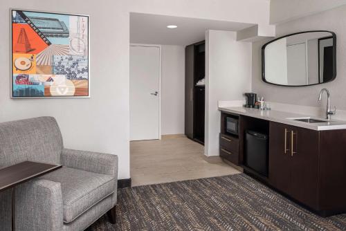 a living room with a couch and a sink and a mirror at Embassy Suites by Hilton Nashville Airport in Nashville