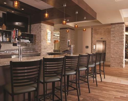 a bar with a row of chairs in a restaurant at Embassy Suites by Hilton Nashville Airport in Nashville