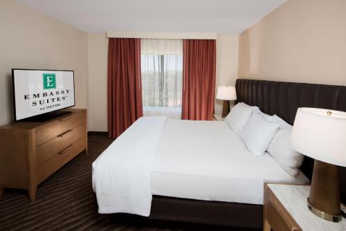 a hotel room with a white bed and a window at Embassy Suites by Hilton Phoenix Scottsdale in Phoenix