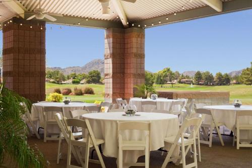a group of white tables and chairs on a patio at Embassy Suites by Hilton Phoenix Scottsdale in Phoenix