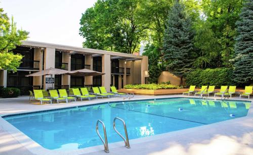 a swimming pool with chairs and a building at DoubleTree by Hilton Portland in Portland