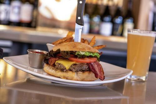 a plate with a hamburger and french fries and a glass of beer at DoubleTree by Hilton Portland in Portland