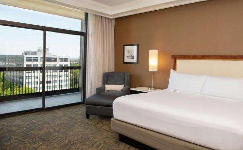 a bedroom with a bed and a chair and a window at DoubleTree by Hilton Portland in Portland