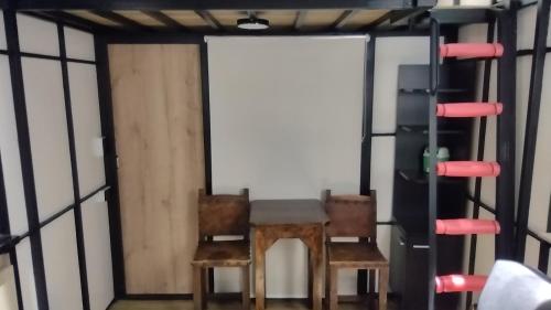 uma mesa e duas cadeiras num quarto com uma janela em Chalet Tanat em Medellín
