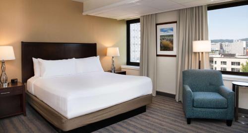 a hotel room with a bed and a chair at DoubleTree by Hilton Portland in Portland