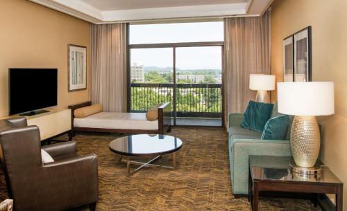 a living room with a couch and a tv at DoubleTree by Hilton Portland in Portland