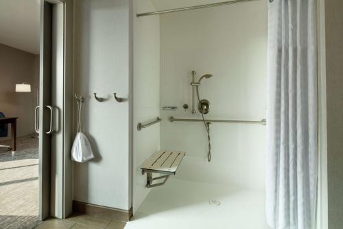 a white bathroom with a bench and a shower at Hampton Inn & Suites Teaneck/Glenpointe in Teaneck