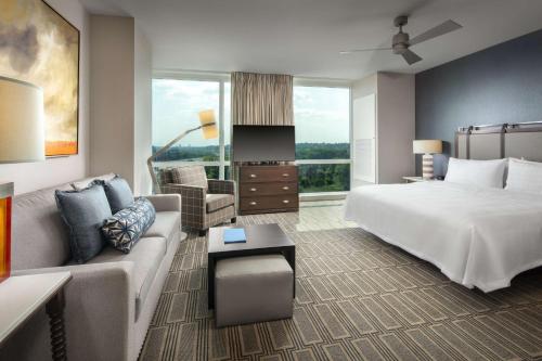 a hotel room with a bed and a couch at Homewood Suites By Hilton Teaneck Glenpointe in Teaneck