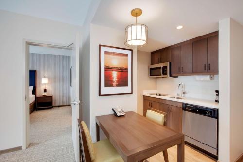 a kitchen and dining room with a wooden table at Homewood Suites By Hilton Louisville Downtown in Louisville