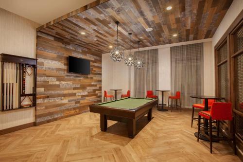 a room with a pool table and red chairs at Homewood Suites By Hilton Louisville Downtown in Louisville