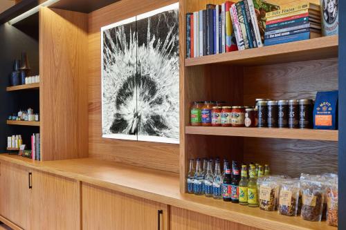 a book shelf filled with bottles of alcohol and books at Canopy By Hilton San Antonio Riverwalk in San Antonio