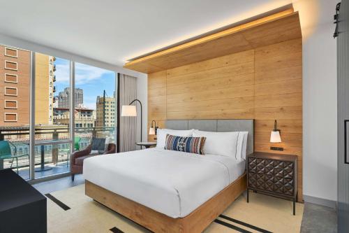 a bedroom with a large bed and a large window at Canopy By Hilton San Antonio Riverwalk in San Antonio