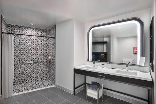 y baño con 2 lavabos y ducha. en Canopy By Hilton San Antonio Riverwalk en San Antonio